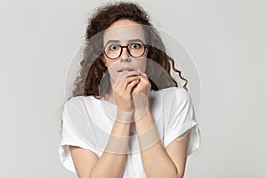 Young stressed fearful woman in eyewear feeling awe.