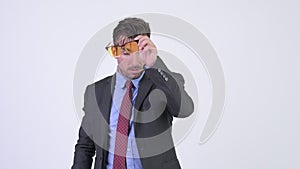 Young stressed Hispanic businessman removing sunglasses and checking time