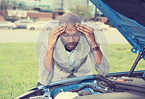 Young stressed man having trouble with his broken car