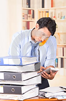 Young stressed overwhelmed man with piles of