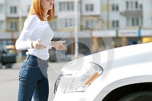 Young stressed woman driver near broken car having a prbreakdown problem with her vehicle waiting for assistance