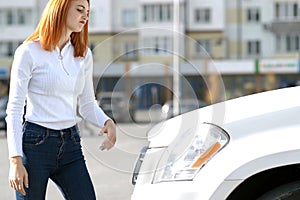 Young stressed woman driver near broken car having a prbreakdown problem with her vehicle waiting for assistance