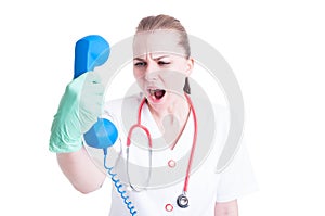 Young stressed woman showing rage and yelling on telephone