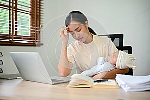 Young stressful mother working from home and raising baby