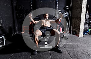 Young strong focused fit muscular man chest bench press stretching workout training in the gym with rubber for strength and good l