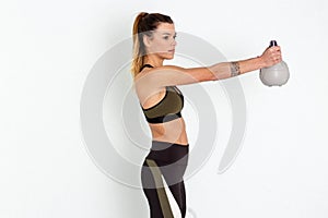 Young strong girl exercising with kettle bell on white background - Image
