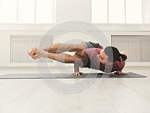 Young flexible man standing on hands photo