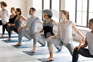 Young strong mixed race people practicing Eka Pada Rajakapotasana.