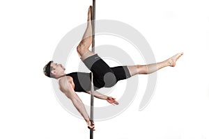 Young strong pole dancer smiling man in black clothes on pylon. White background