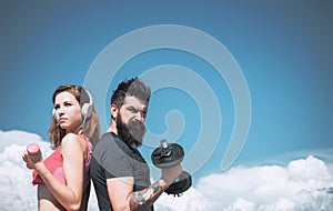 Young strong sporty couple working outside with sports equipment at beautiful blue summer sky background. Active