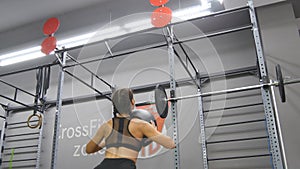 Young strong woman with perfect fitness body in sportswear exercising with medicine ball at gym. Girl doing crossfit