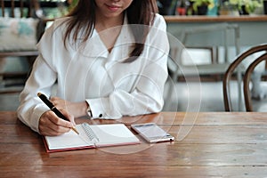 Young student woman holding pen for writing on notebook paper an