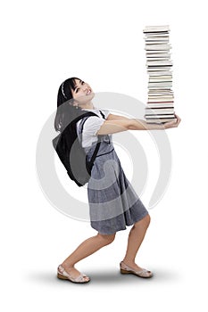 Young student carrying many books