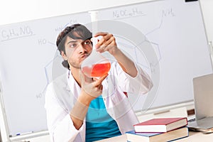 The young student chemist in the classroom