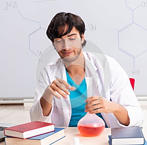 Young student chemist in the classroom