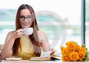 Young student drinking coffee while sudying