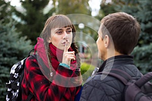 Young student friends talking at college. Girl try to prove something pointing finger.
