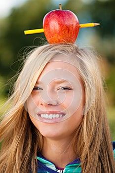 Young student girl with apple on her head