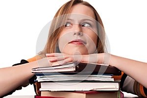 Young student girl with head on top of books pile