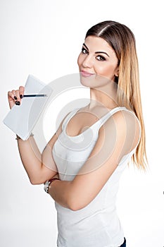 Young student girl with notebook and pen planning her daily schedule wearing casual white t-shirt on white. Studio retouched shot