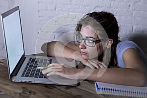 Young student girl studying tired at home laptop computer preparing exam exhausted and frustrated feeling stress