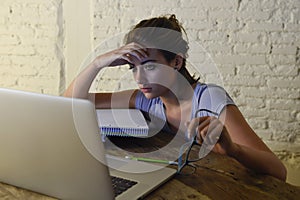 Young student girl studying tired at home laptop computer preparing exam exhausted and frustrated feeling stress