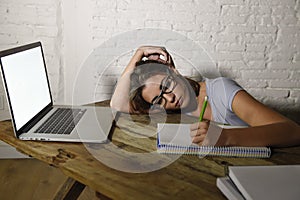 Young student girl studying tired at home laptop computer preparing exam exhausted and frustrated feeling stress