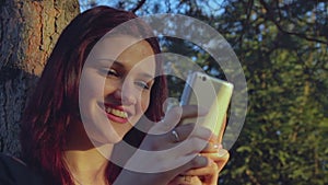 Young student girl using her smartphone outside