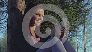 Young student girl using her smartphone in a park