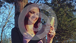 Young student girl using her smartphone in a park