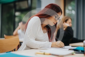 Focused students taking notes in a bright classroom setting