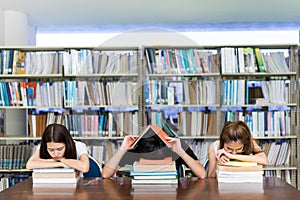 Joven alumno grupo lectura un libro grave duro un examen prueba durmiendo dolor de cabeza preocupaciones en la clase educación biblioteca universidad 