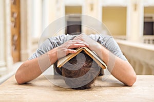 Young student guy studying a boring subject