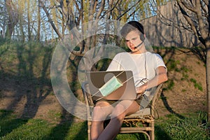 Young student in isolation, attends university courses on laptop with headset