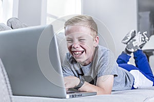 Young student laughing during a web conferencing meeting doing school work from home