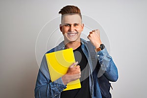 Young student man wearing denim shirt backpack notebook over isolated white background screaming proud and celebrating victory and