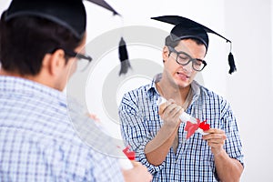 The young student planning graduation speech in front of mirror
