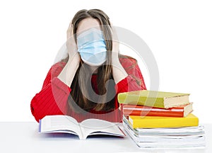 Young student in protective mask with books.  Pupil girl, teenage girl in protective medical mask on face, frustrated.