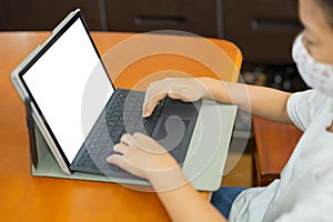 Young student with protective mask hands typing on laptop.