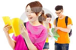 Young student reading a book with classmates and laughing