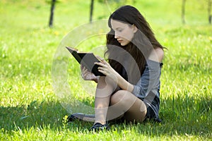 Young student reading book meadow