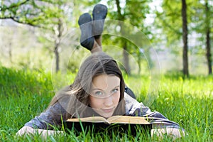 Young student reading book in park