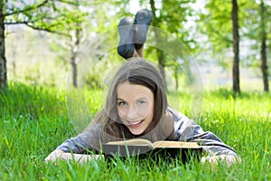 Young student reading book in park