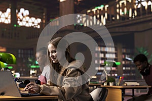 Young student reading and writing detailed notes for an exam at the college