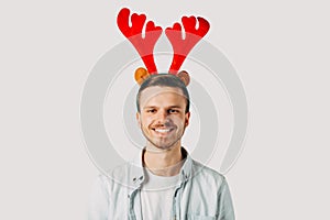 Young student with red horns, in a blue shirt before Christmas