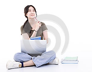 Young student sitting on the floor with laptop and looking up