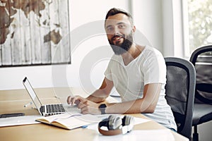 Young student sitting at the table and use the laptop