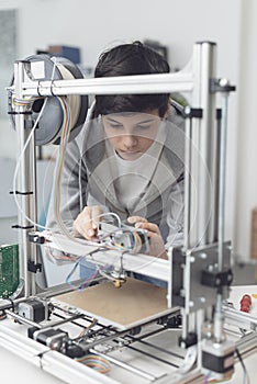Young student using a 3D printer in the lab