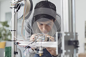 Young student using a 3D printer in the lab