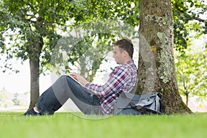 Young student using his laptop to study outside